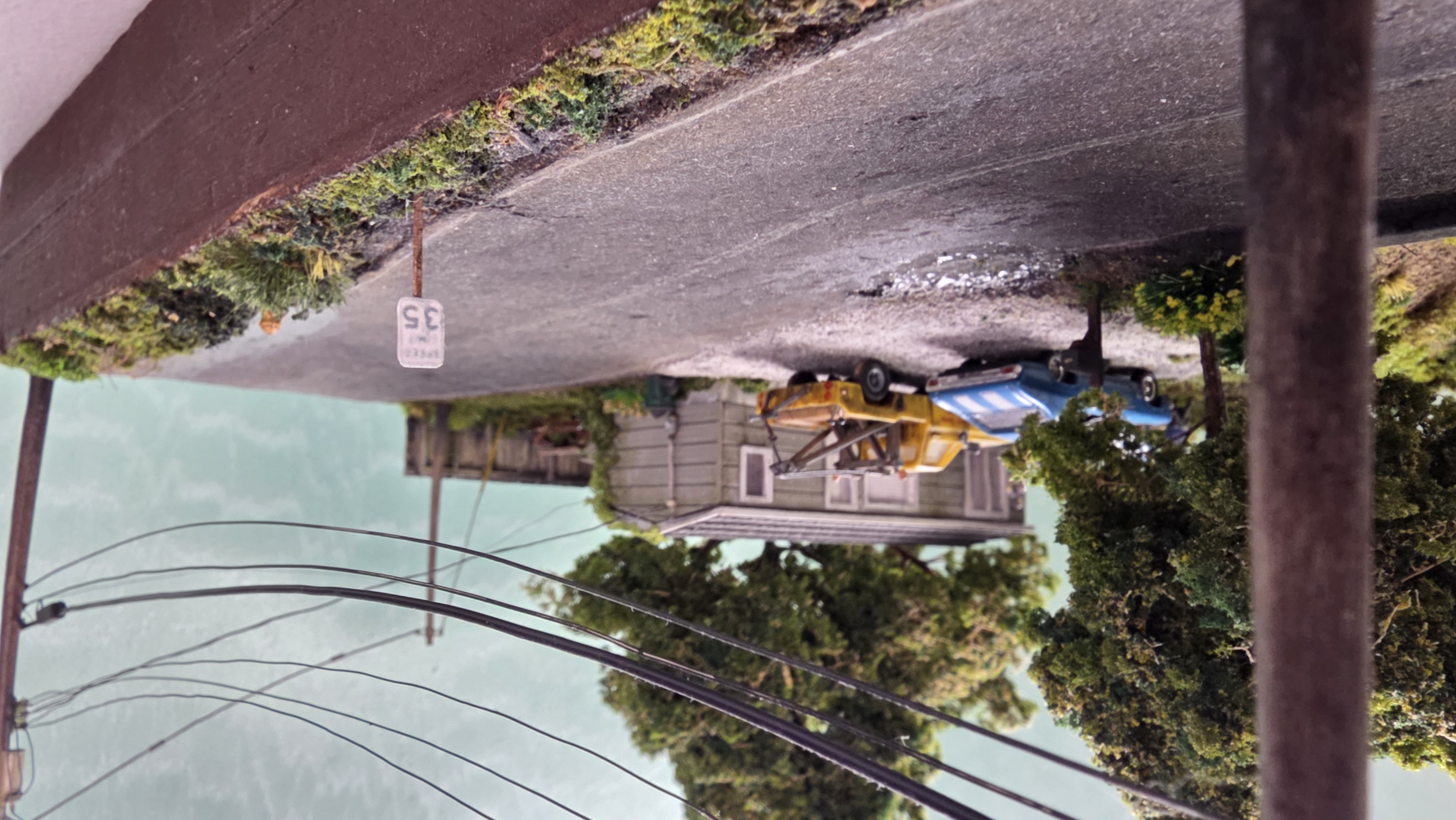 Roadside view down the gravel drive — telephone poles and power lines overhead, the 35 mph speed sign at the shoulder