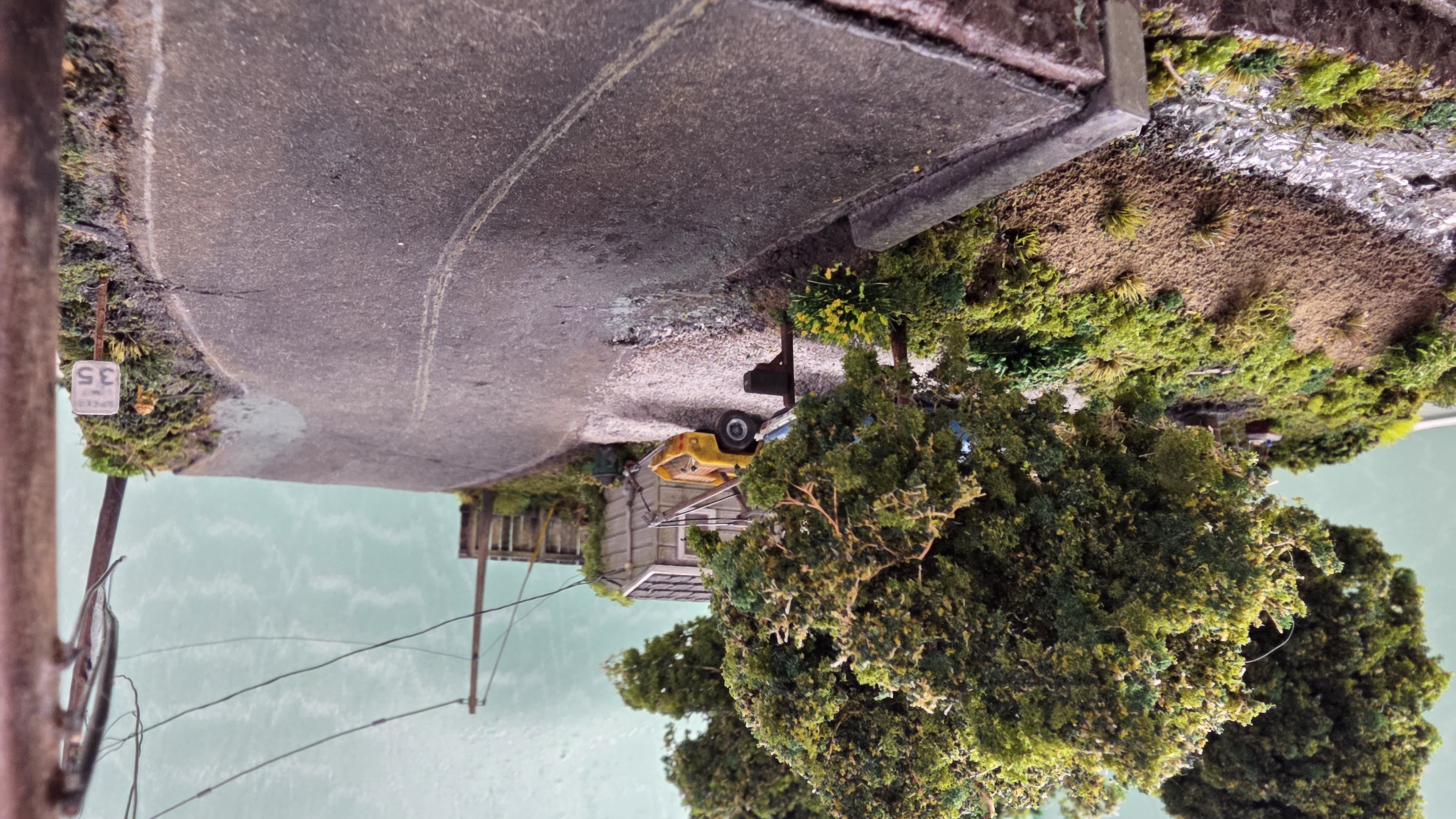 Hand-built sea-foam trees lining the weathered shingle-tab road at the diorama's edge